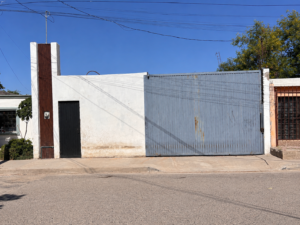 Fachada urbana con portón y puerta negra